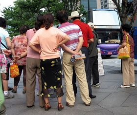 一零一大楼景点前的真相展板围着层层的中国游客争相了解事实、听学员讲真相