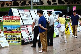 '二零一一年七月十六日，韩国八大市民团体与法轮功学员冒雨在首尔广场举行联合集会，谴责中共对法轮功长达十二年的人权迫害。图为集会现场一角。'
