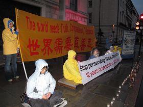 法轮功学员冒雨在中共英国伦敦大使馆前举行反迫害烛光守夜活动