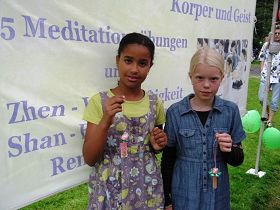 两位小姑娘自豪地展示她们自己亲手折的纸莲花