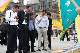 中国旅游者在展板前驻足，了解法轮功真相