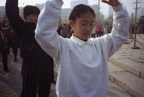 一九九九年四月初，几个炼功点的近千名法轮功学员在沈阳和平广场晨炼——炼功人群中的小学生。