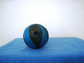 孔雀翎球直径约10cm（制作第一步是把白色泡沫做的圆球去掉多余部分，磨平，然后涂上黄胶，把染上蓝色的可能是鹅毛粘在球上，再把四个孔雀毛涂上胶粘上）