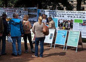 芬兰法轮功学员在首都赫尔辛基的海滨公园举办讲真相活动，人们纷纷停下脚步了解真相。
