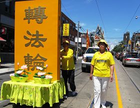 吴艳霞（右）参加二零一二年多伦多庆祝法轮大法日大游行经过唐人街