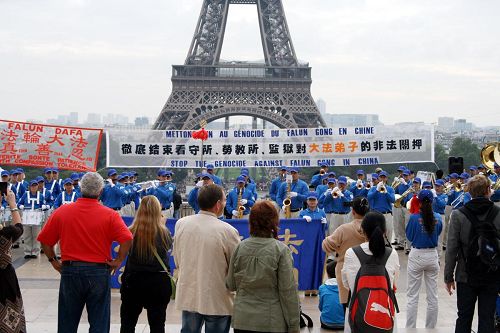 '欧洲部份法轮功学员在巴黎铁塔前集会，展现法轮功的美好，并揭露中共活摘器官等种种罪行。'