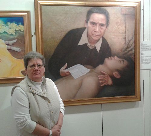 '图1：朱迪思·乌德曼议员站在让她感到震撼的“真善忍国际美展”作品前'