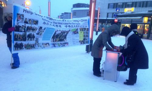 图1-3：法轮功学员在地处北极圈的芬兰罗瓦涅米市征签，谴责中共迫害