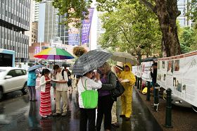 悉尼部份法轮功学员冒雨在市政厅大楼前举办征签活动