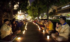 '二零一三年四月二十五日，洛杉矶法轮功学员在中领馆前集会，用烛光悼念在中共持续十四年的残酷迫害中失去生命的法轮功学员。'