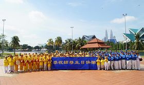 '活动结束前法轮功学员在蒂蒂旺莎湖滨公园广场合影，恭祝师尊生日快乐。'