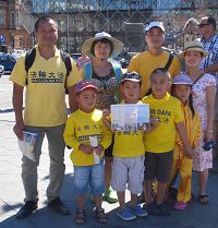'图3：来自捷克的两位越南裔法轮功学员带着家人和孩子参加了“七二零”法轮功哥本哈根大游行，并在市政厅广场上发放法轮功真相传单'