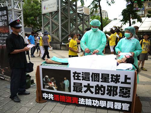 图1：八月二十四日台北大安森林公园路口举办以真人演示活摘器官的行动剧，揭露中共的暴行。
