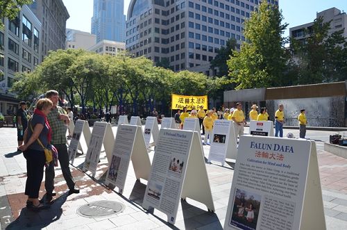 图1：西雅图法轮功学员在市中心摆放介绍法轮功的展板并演示法轮功功法