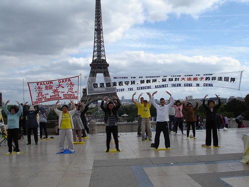 图1：法轮功学员在巴黎埃菲尔铁塔前传播法轮功的真相。图为法轮功学员正在演示第二套功法。