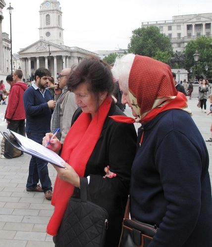 '两位移居伦敦的波兰女士互相鼓励在反迫害征签表上签名'
