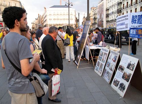 图1：二零一四年十月三日傍晚，马德里市中心的太阳门广场上，民众认真阅读法轮功真相展板