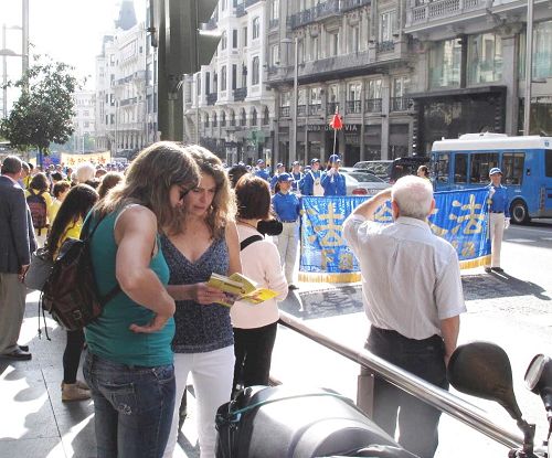 图2：二零一四年十月四日，法轮功学员在马德里举行盛大游行，很多人接过真相传单，认真阅读