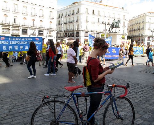 图8：艾丽（Eli）骑车经过太阳门广场时，赶上了欧洲法轮功学员的反迫害集会