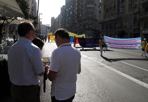 图11：电器工程师马克罗（Macro）和安吉尔（Angel）在马德里大街上认真观看法轮功学员的反迫害大游行