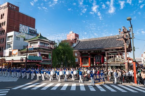 游行队伍通过雷门，很多大陆游客拥在路旁观看