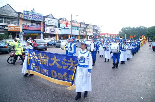 '法轮功游行队伍走在士古来大学城主要大街上,不但传播着法轮功的真相,也给当地民众带来过年的喜庆。'