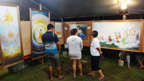 第三十三届塞班岛火树节，游客观赏“真善忍国际美展”画作