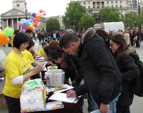 人们在反对中共活摘法轮功学员器官的征签表上签字