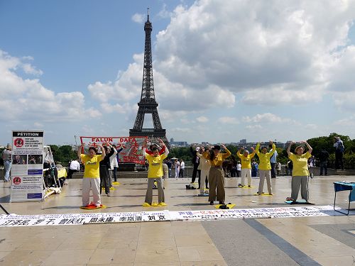 图1-5：巴黎学员在著名景点艾菲尔铁塔下的人权广场传播法轮功真相，吸引四方来客驻足了解。