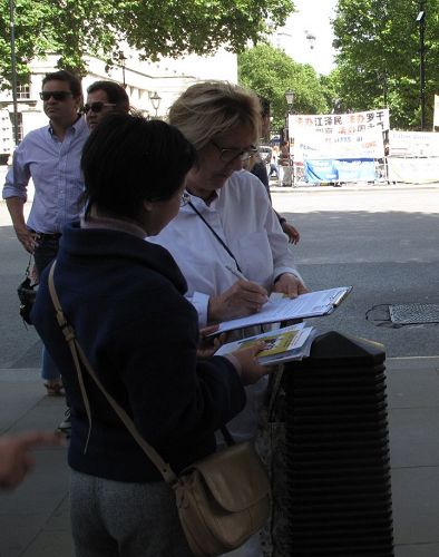 六月十七日下午，路过唐宁街大门外的英国女士杰西（Jesse）在反活摘征签表上签名