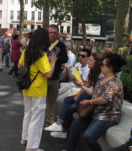 在英国生活多年的香港女士安娜（右）看到法轮功学员的游行队伍非常高兴