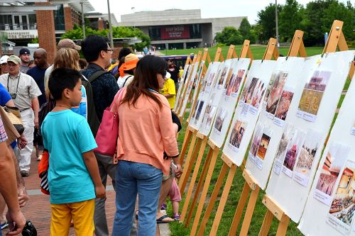 在自由钟广场，大批中、西方游客认真阅读讲述法轮功真相的展板和图片。