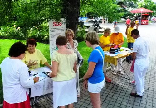 克里米亚自治共和国的法轮功学员在赛瓦斯堡市中心公园,举行讲真相、反迫害征签活动。民众在了解真相后,纷纷签名反对中共活摘暴行。