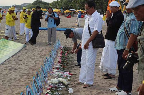 图6-11：游客们在被中共迫害致死的法轮功学员遗照前献花。