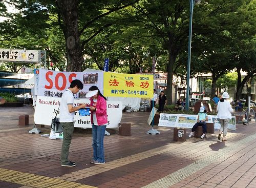 在爱知县名古屋市最繁华地段之一的荣（Sakae），行人在反中共活摘法轮功学员器官的签名薄上签字。