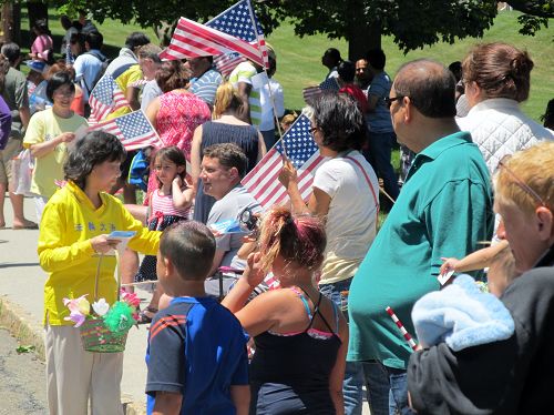 热情的游行观众接受法轮功学员的传单