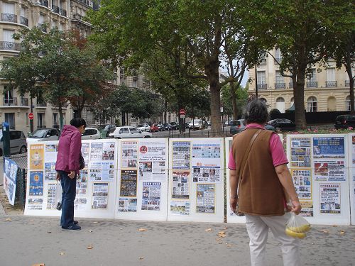 图1-3：巴黎旅游景点上的真相横幅吸引很多中国人驻足观看