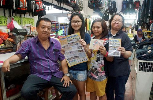 一家卖布料等用品的店铺老板刘先生（左一）与职员开心合照。