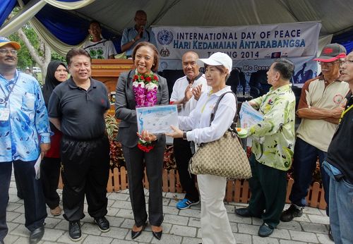 法轮功团体代表接受联合国驻马来西亚协调员蜜雪儿颁发的感谢状