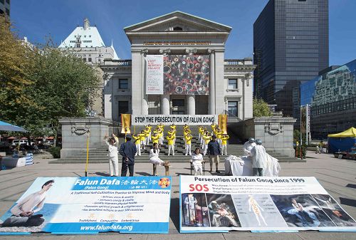 图1：温哥华法轮功学员在市中心艺术馆附近举行讲真相活动，呼吁制止中共迫害法轮功。