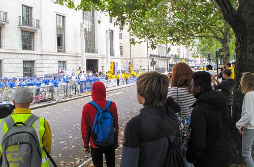 图3：二零一五年十月十日，法轮功学员在在伦敦中使馆对面举行新闻发布会，一个住宿学校的老师带着九个学生恰巧路过，师生们第一次听到法轮功真相