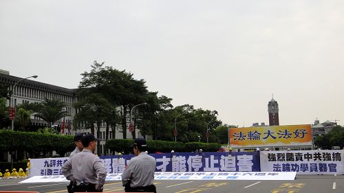 图4：值勤的台湾警察在一旁好整以暇的看着法轮功学员井然有序的集会活动。