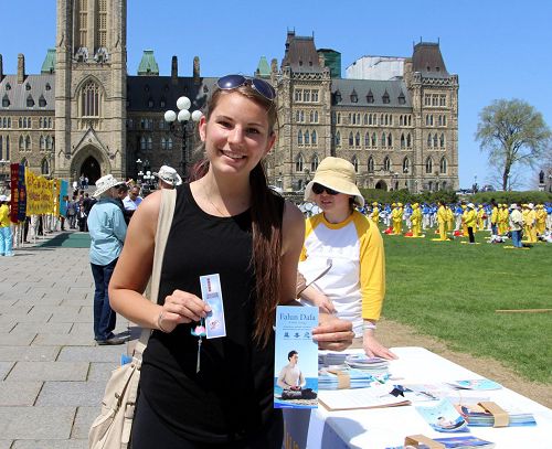 来自魁北克的Cloe是在渥太华上大学的学生，主动来到展位前要求签名反迫害。