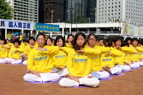 图：法轮功学员在香港中环爱丁堡广场排字与炼功。