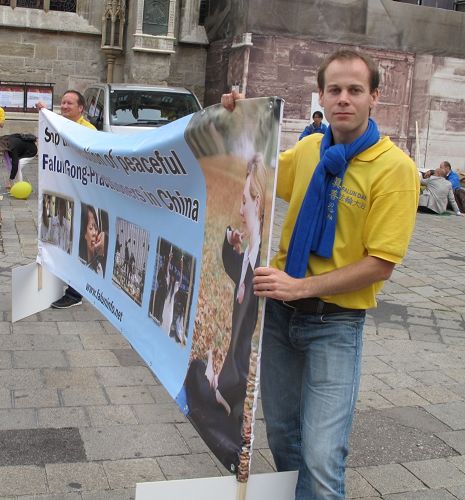 图：九月十九日，西人法轮功学员迈克（Michael）参加了在维也纳斯特凡广场讲真相街头剧的演出，负责打出真相横幅并切换剧幕场景