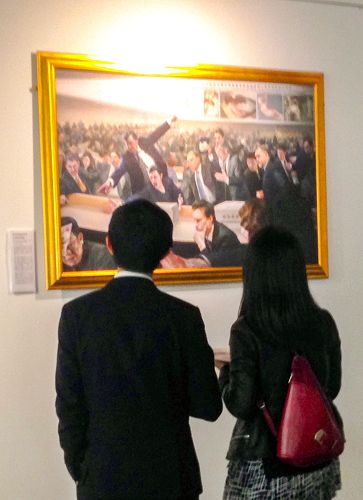 图1：二零一五年九月二日，“真善忍”美展在东伦敦傲案中心（The Proud Archivist）展出，两位华人青年认真观看画作