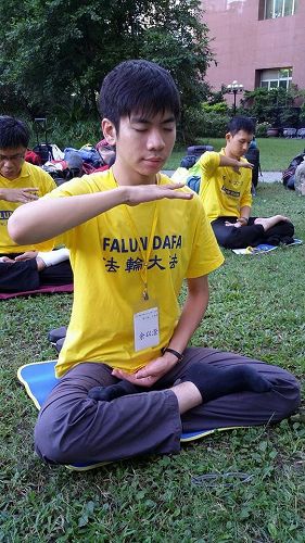 图2. 余以澄（前一）参加二零一四年七月举办的青年学子交流营，图为当时在中国医药大学校园炼功的照片。