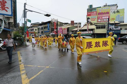 '图2：腰鼓队精神抖擞的挥动鼓棒前进。'