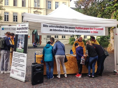'图1～4：海德堡市民在要求停止活摘器官的征签表上签字'