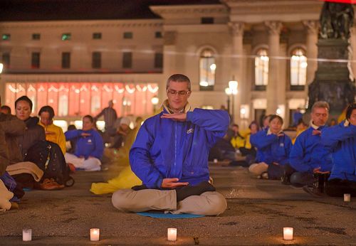 '图10-11：欧洲法轮功学员在德国慕尼黑的Max-Joseph广场举行烛光守夜活动。 祥和场面，吸引不少过往行人驻足了解真相。'